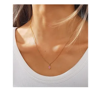 Close-up of a delicate 18K gold-plated chain featuring a soft pink oval gemstone pendant