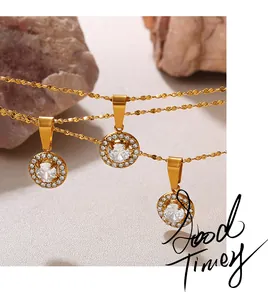 Detail of 18K gold plated necklaces with round zircon pendants on a textured rock surface