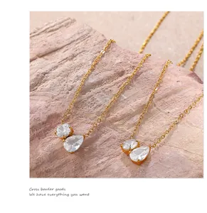 Detail of 18K gold-plated necklace featuring round and teardrop-shaped clear crystals