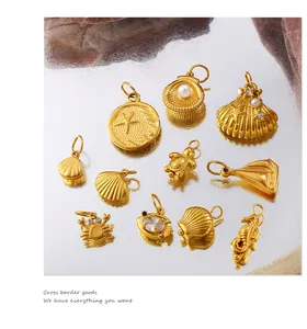 Macro shot of 10 gold sea charms with pearls and zircons on a reflective surface