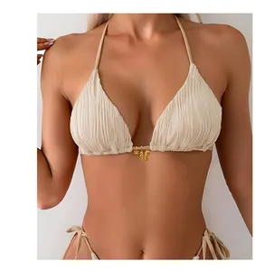 Detail of cream pleated bikini with gold sea creature charms including crab and seahorse