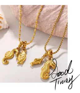 Macro detail of 18K gold plated sea life pendants featuring seahorse and dolphin motifs