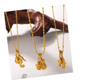 Macro shot of 18K gold plated marine charms with seahorse and turtle on wooden background