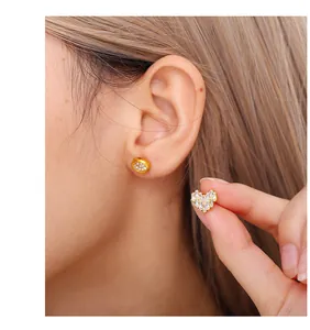 Gros plan sur boucle d'oreille cœur en or avec zircons baguette et pavé serti
