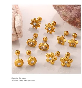 Détails de boucles d'oreilles dorées avec formes de fleurs coeurs et zircons blancs