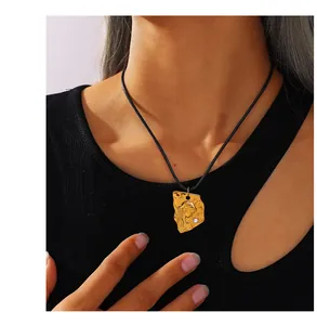 Détail d'un pendentif portrait vintage en or avec zircon sur un collier cordon noir