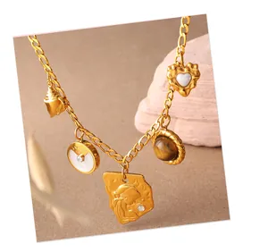 Détail d'un collier doré vintage avec pendentifs coquillage, pièce et cœur