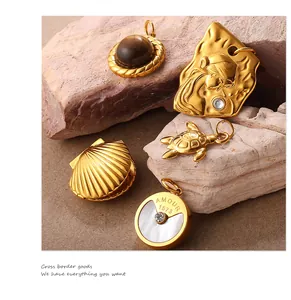 Détail de cinq pendentifs dorés comprenant tortue, coquillage et pierre œil de tigre
