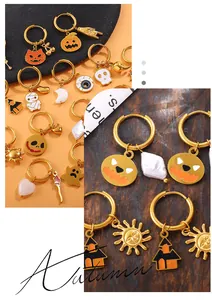 Detail of Halloween charms on 18K gold earrings featuring pumpkin, ghost and mummy patterns