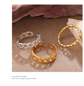 Detalle de los anillos con textura de cadena en oro y plata sobre fondo de piedra natural