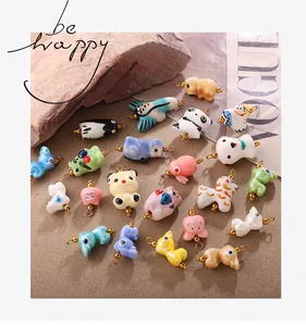 Détail de pendentifs animaux en céramique faits main avec boucles dorées pour bijoux DIY