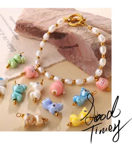 Détail du bracelet en perles avec breloques animaux en céramique et fermoir doré