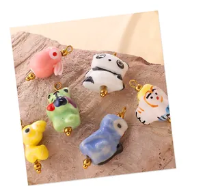 Détail de breloques animaux en céramique pour bijoux DIY avec finition glacée et boucles dorées