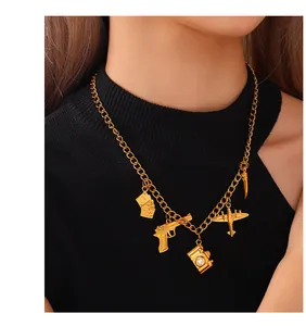 Close-up of golden link necklace featuring retro gun, camera, and music pendants