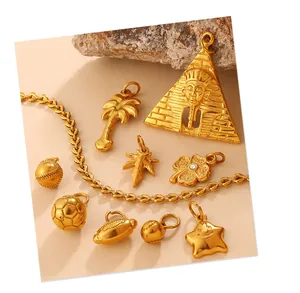Detailed collection of gold sports ball pendants and Egyptian pyramid charms on beige stone