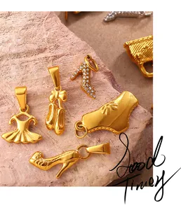 Dettaglio di ciondoli in oro 18K con abito da ballo e scarpe su sfondo di pietra rosa