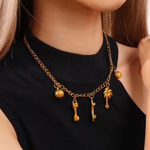 Gold chain necklace with football, dumbbell, and skateboard charms on black sweater