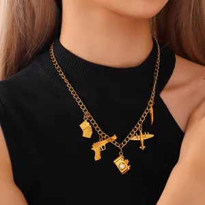 Vintage gold necklace featuring charms of camera, gun, and plane on black sweater