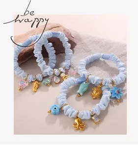 Detail of light blue scrunchies with golden marine charms like seahorse and turtle