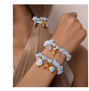 Light blue ocean-themed scrunchies with seahorse and starfish charms worn as bracelets
