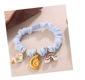 Detail of light blue scrunchie with cute ocean shell, rainbow, and flower charms