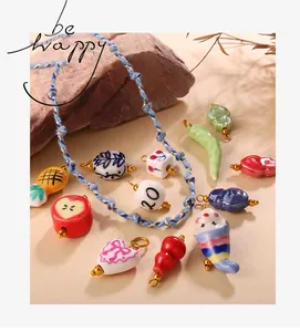 Detailed view of handmade ceramic charms with golden loops and colorful hand-painted patterns