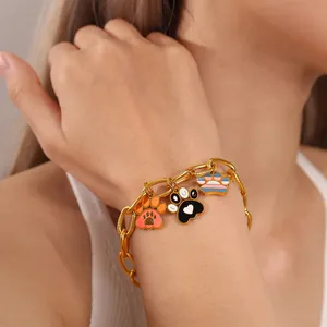 Gold chunky chain bracelet with colorful paw print charms on a female model's wrist