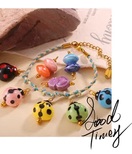 Detail of colorful ladybug charms on a braided bohemian bracelet with a gold steel clasp