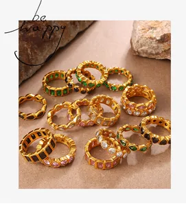 Détail de bagues plaquées or avec zircons colorés en forme de cœur et carrée