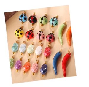 Selection of colorful ceramic ladybug and heart charms with gold rings for DIY jewelry making