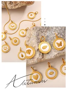 Macro shot of gold-plated charms with white inlay featuring butterfly and heart patterns