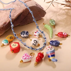 Handmade ceramic ladybug and fruit charms with blue woven cords on natural stones