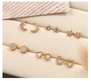 Détail d'un lot de six paires de boucles d'oreilles dorées avec strass feuille et cœur sur velours