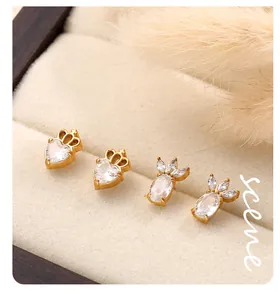 Gros plan de boucles d'oreilles dorées en cristal avec détails couronne et feuilles