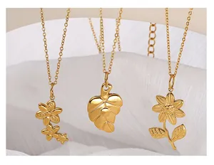 Detailed close-up of three gold vintage insect and flower pendants on white silk
