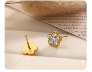 Vue macro de boucles d'oreilles fleurs dorées avec strass brillants et finition délicate