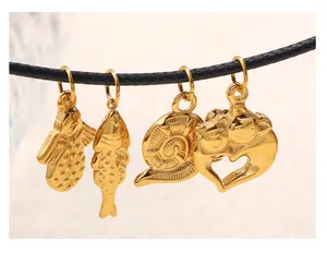 Detailaufnahme goldener Anhänger in verschiedenen Formen an einer schwarzen Kordel