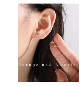 Gros plan détaillé de boucles d'oreilles dorées avec feuilles, cœurs et zircons