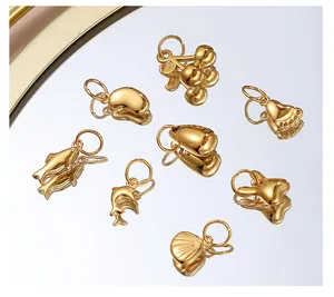 Macro shot of assorted gold-polished metal charms including dolphin and shell shapes