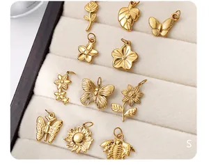 Macro shot of gold vintage insect and floral charms in a velvet display jewelry tray