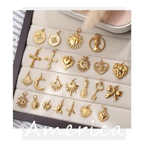 Assorted gold stainless steel charms including sun and moon motifs in a velvet box