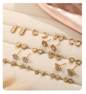 Détails de boucles d'oreilles dorées avec motifs lune cœur et étoile sur velours