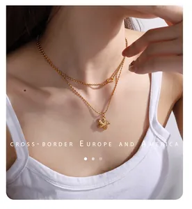 Detail einer mehrlagigen Goldkette mit Seestern-Anhänger am Modelhals