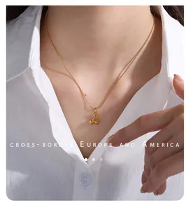 Gold cherry pendant necklace on a thin chain worn with a professional white shirt