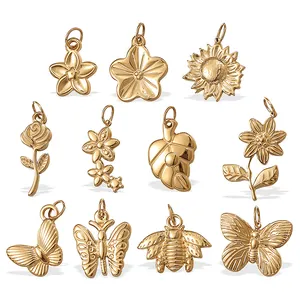 Set of 11 vintage gold stainless steel floral and insect charms on white background