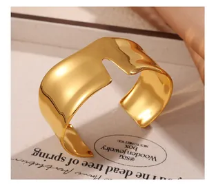 Vista dettagliata dell'ampio bracciale placcato oro 18k con finitura a specchio e forma organica