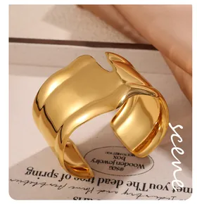Dettaglio del bracciale rigido in acciaio inossidabile dorato con design a onde irregolari