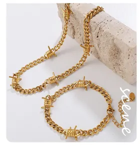Detailansicht von goldenem Dornen-Halsketten- und Armbandset auf Steinsockel