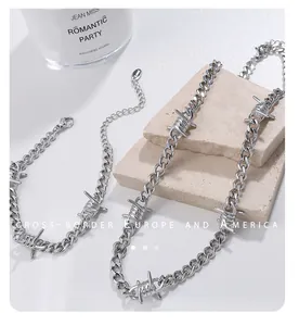 Silbernes Barbed Wire Punk Schmuckset mit Kette und Armband auf strukturiertem Stein