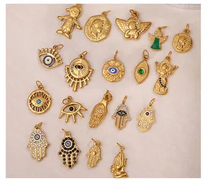Dettaglio di vari ciondoli placcati in oro 18K inclusi la mano di Fatima e l'occhio greco